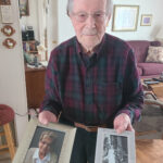 Armand Martin poses with photos of his two wives, both named Yvette in Madawaska on Feb. 11. (Emily Jerkins | St John Valley Times)